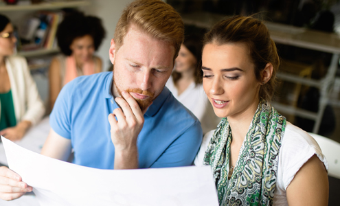 Two people looking at a large piece of paper